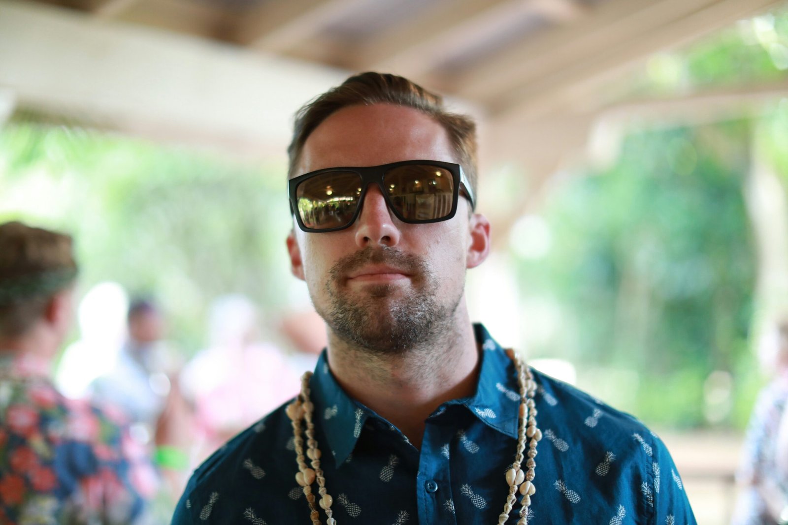 man in blue and yellow floral button up shirt wearing black sunglasses